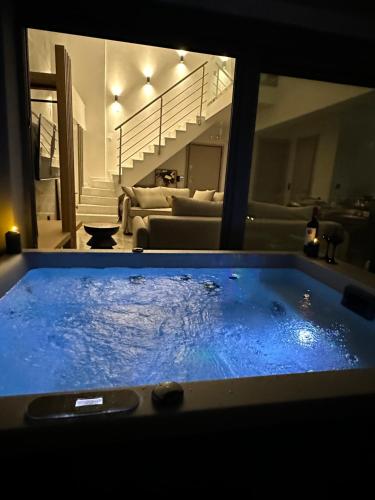a large blue hot tub in a living room at Artion Jacuzzi Villa Nikiti in Nikiti