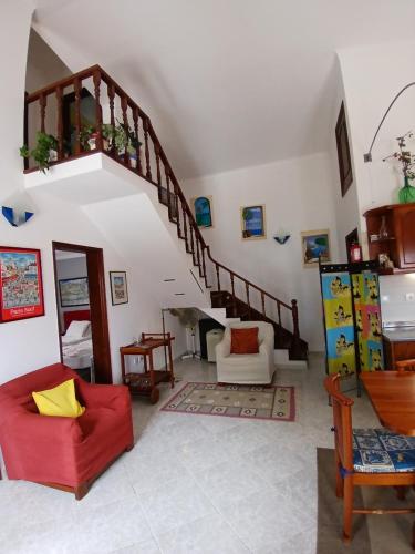 a living room with a red couch and a staircase at Campo de Oleandros in Lourinhã