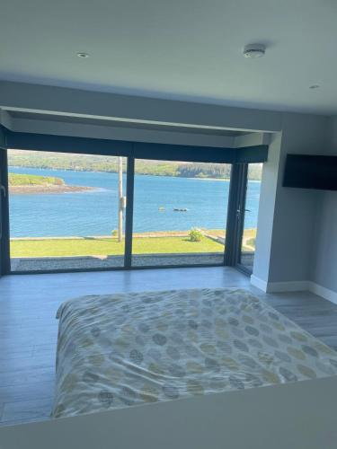 a bedroom with a large view of the water at Tigh an Trá in Bantry