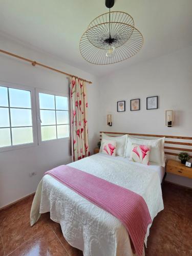 a bedroom with a large white bed with pink pillows at Roque`s House A in Telde