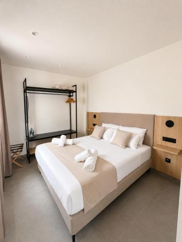 a bedroom with a large white bed with towels on it at OMO STAYS Pinada Park in Guardamar del Segura