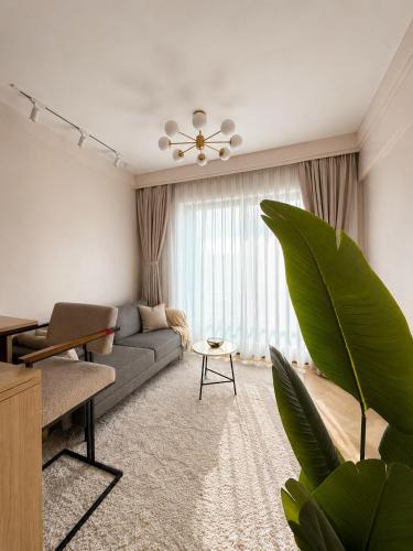 a living room with a couch and a large window at Oderm one bedroom apartment in Syokimau near jkia airport and sgr station in Nairobi in Nairobi