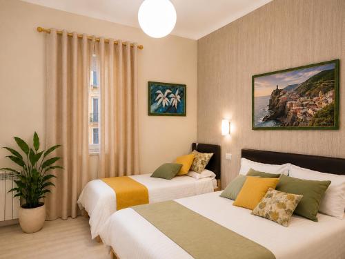 a hotel room with two beds and a window at Il Quadrifoglio guesthouse in La Spezia