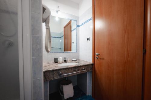 a bathroom with a sink and a mirror at Villaggio Torre Ruffa Robinson in Capo Vaticano