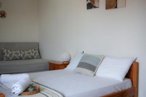 a bedroom with a white bed and a couch at Boho Center Studio in Keramoti
