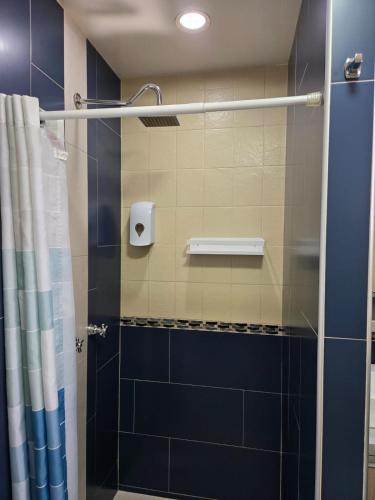 a shower with a blue and white shower curtain at Independent apartment in San Antonio