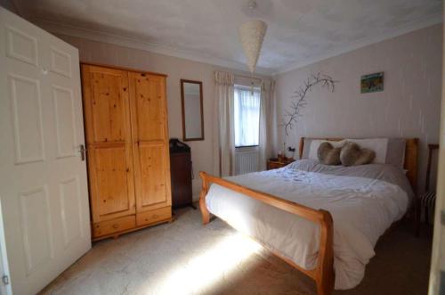 a bedroom with a large bed and a window at The Annex - Guest Gardens in Milton Keynes
