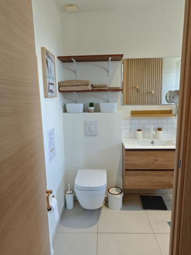 a small bathroom with a toilet and a sink at Villa Dérimbeault in Oyster Pond