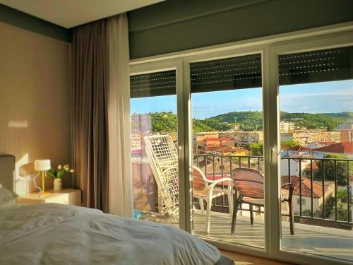 a bedroom with a bed and a view of a balcony at Luxury Apartment in Shkodër
