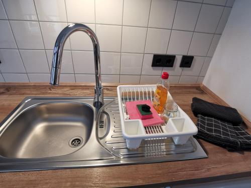 a kitchen sink with a dish drying rack in it at Vielstubenhaus - FeWo August in Pirna