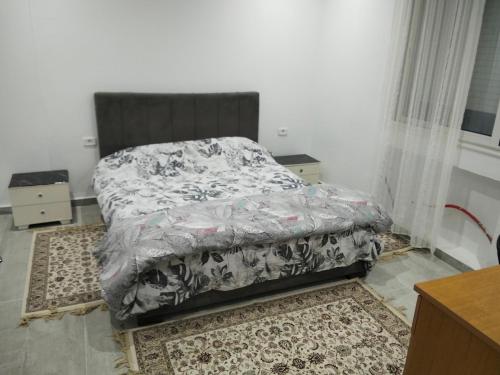 a bedroom with a bed and a dresser at Résidence Rahma in Hammam Chott