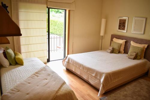 a bedroom with two beds and a sliding glass door at Casa da Aldeia in Penafiel