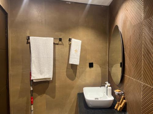 a bathroom with a sink and a mirror at HSQ Towers in Murree