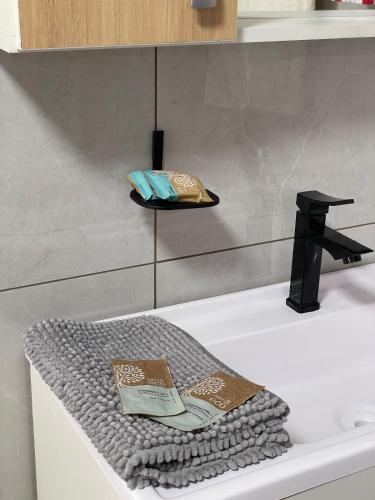 a bathroom with a bath tub with a towel and a sink at suíte perto da praia in Imbituba
