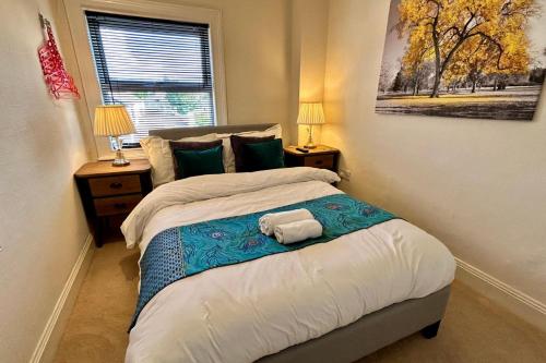 a bedroom with a bed with two lamps and a window at Character Bedford Apartment with Two Bedrooms in Bedford
