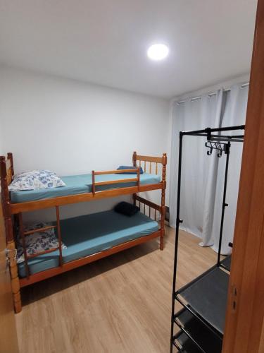 a room with two bunk beds and a tripod at Lugar tranquilo in Biguaçu