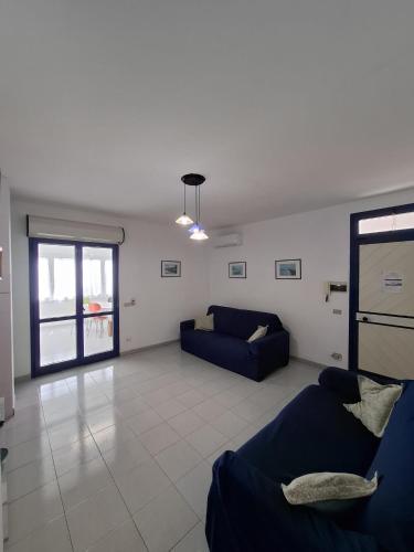 a living room with two blue couches and a window at La casa del delfino in Policoro
