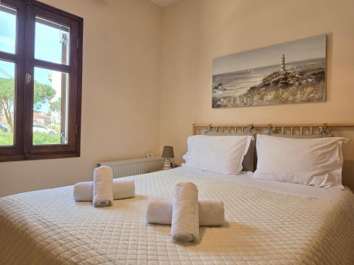 a bedroom with a large white bed with a window at Master Residence Lavrion in Lavrio