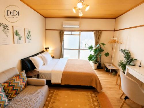 a bedroom with a bed and a couch at ゲストハウス DiDi 103 Private Apt near Park 10min from Station Netflix in Tokushima