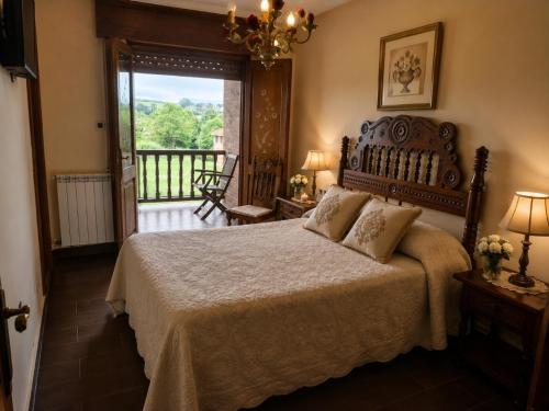a bedroom with a large bed and a balcony at Hospedaje Villa Pilar in Santillana del Mar
