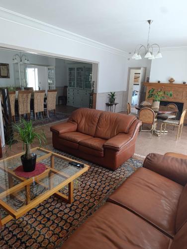 a living room with a leather couch and a table at Trégouet 8 - Chambre 3 in Saint-Nazaire