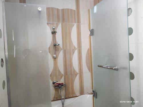 a shower with a glass door next to a tub at Chery Private Suite in Marsa Alam City