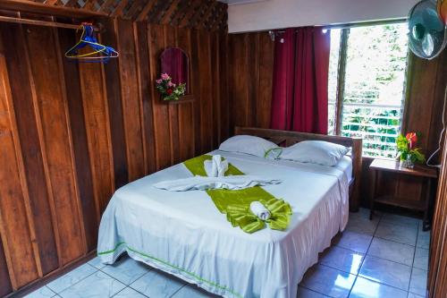 a bedroom with a bed with a green bow on it at Hospedaje Angeluz in Quesada