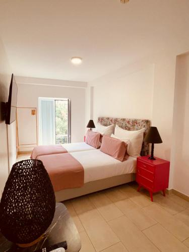 a bedroom with a large bed and a window at Esmeralda Holidays Apartments in Funchal