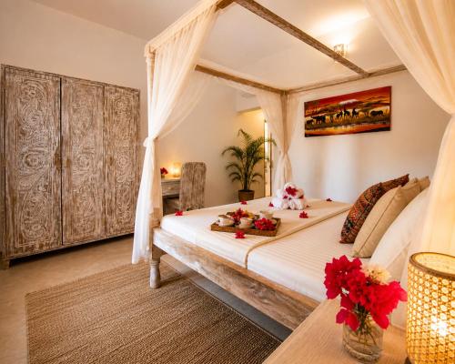 a bedroom with a bed with flowers on it at Blue Diamond Villa Watamu in Watamu
