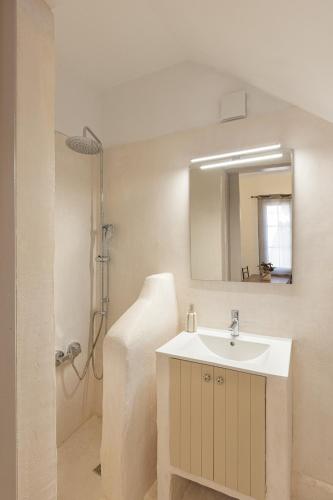 a bathroom with a sink and a shower with a mirror at Aesop Homes in Pythagoreio