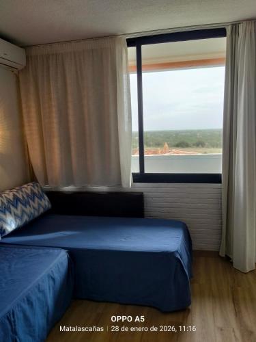 a bedroom with a bed and a large window at Estudio DUNA BLANCA in Matalascañas