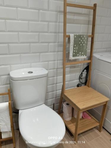 a bathroom with a white toilet and a shelf at Estudio DUNA BLANCA in Matalascañas