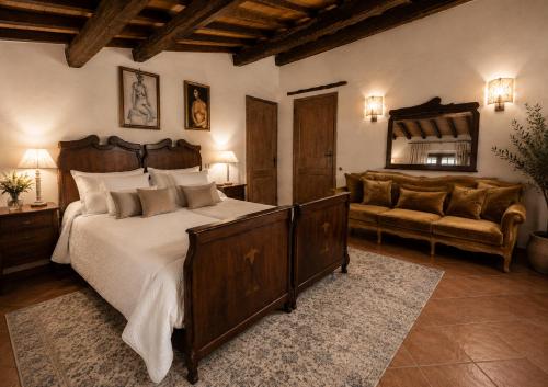 a bedroom with a bed and a couch and a mirror at LA MORA Exclusive in Moricone