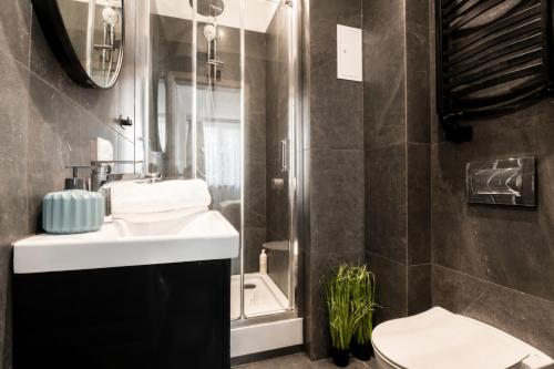 a bathroom with a sink and a toilet at PiotrApartments - Central Warsaw Wilcza - Luxury Apartment - Prime Location in Warsaw