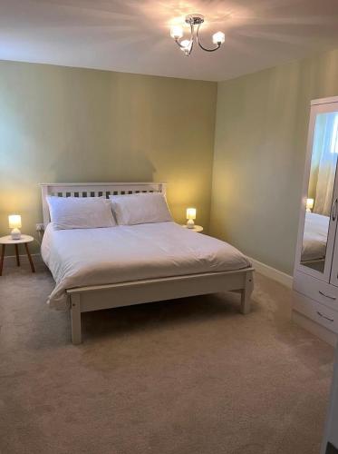 a bedroom with a bed with two lamps and a mirror at Knockeven Hidden Gem in Waterford