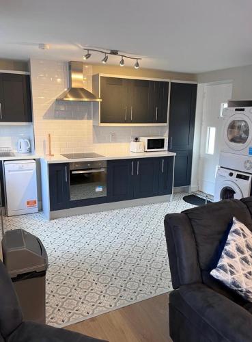 a large kitchen with blue cabinets and a couch at Knockeven Hidden Gem in Waterford