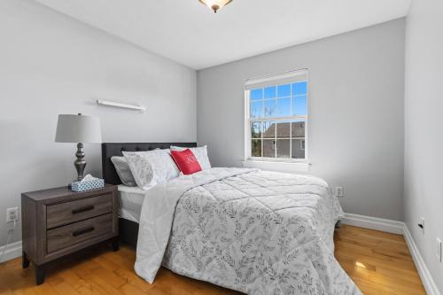 a white bedroom with a bed and a window at Spacious 4BR Family Retreat w- Game Room 10p in Dieppe