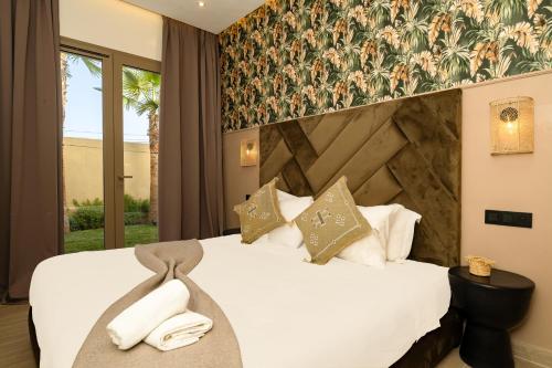 a hotel room with a bed with two towels on it at Luxurious Marrakech Villa Pool, Hammam,Cinema in Marrakesh