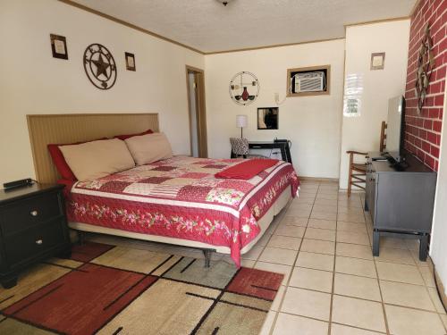 a bedroom with a bed and a desk and a television at Canton Motel in Canton