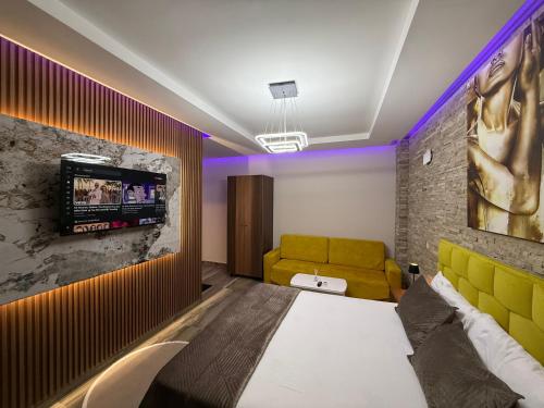 a room with a couch and a tv on a wall at Hotel Exclusive in Tirana