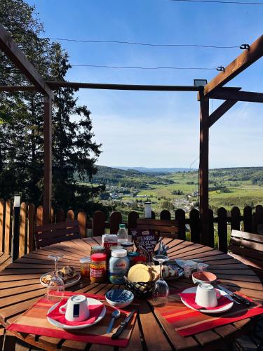 a wooden table with food on top of a deck at La Bastide en Margeride in Châteauneuf-de-Randon