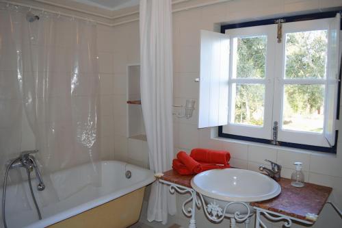 a bathroom with a tub and a sink and a window at Monte do Rei Santo in Arronches