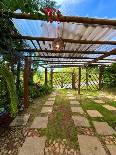 a wooden pergola with a hanging flower arrangement at Chalé no coração de Penedo - Pet Friendly in Itatiaia