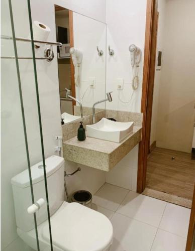a bathroom with a toilet and a sink and a mirror at Alugo Suite 303 No Mont Blanc in Nova Iguaçu