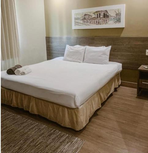 a bedroom with a large bed with white sheets and pillows at Alugo Suite 303 No Mont Blanc in Nova Iguaçu