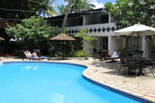 a swimming pool in front of a house at Capricorn International Hotel in Nadi