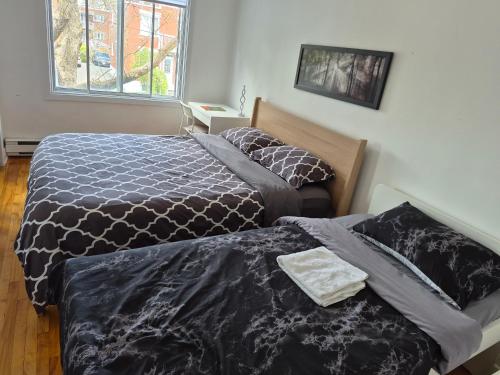 a bedroom with two beds and a window at Confort belles chambres privées dans un duplex in Montreal