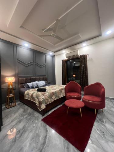 a bedroom with a bed and two chairs and a table at Aura Villa in Ghaziabad