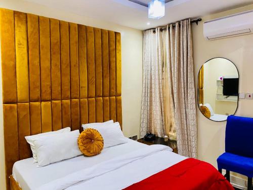 a bedroom with a bed with a large wooden headboard at Servy Hotels in Port Harcourt