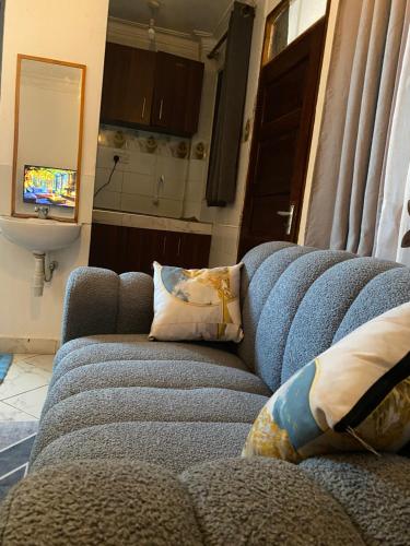 a blue couch with pillows in a living room at Imastay in Mombasa